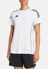 Maglietta sportiva bianca a maniche corte con accenti neri e tre strisce sulle spalle, realizzata in tessuto traspirante. Presenta un collo rotondo.