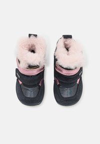 Chaussures pour enfants bleu marine avec une bordure en fausse fourrure rose, des bandes auto-agrippantes, des côtés à motifs et des semelles en caoutchouc pour une meilleure adhérence.