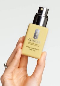 Clinique fuktighetslotion med SPF 35 i en gul rektangulær flaske. Har en sølvlogo og en svart spraydyse.