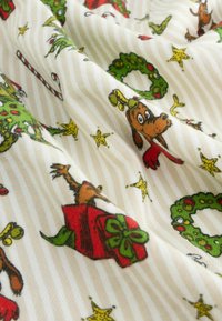 Tessuto di cotone con uno sfondo a strisce crema, contrassegnato da colorati cani dei cartoni animati, alberi di Natale, ghirlande, regali e stelle.