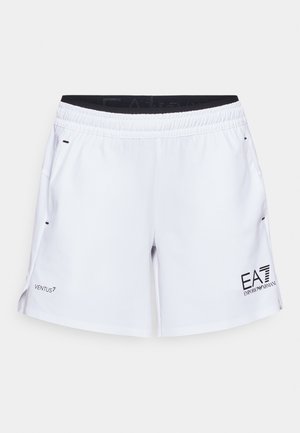 Hvite treningsshorts med elastisk midje, sidelommer og svart merkevare. Har en glatt tekstur og splittede sidesømmer for bevegelsesfrihet.