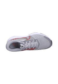 Grijze Nike hardloopschoen met een bovenwerk van mesh, rode accenten, platte veters en een gevoerde zool. Opvallend gestructureerd patroon op het bovenwerk.