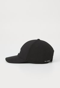 Svart caps med avrundet krone, stiv brem og logo foran; har teksturert stoff og justerbar bakre stropp.