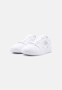 Baskets basses blanches en matière synthétique, avec logo embossé, design à lacets et semelle extérieure en caoutchouc texturé.