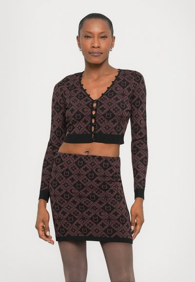 Cropped, long-sleeve knit top and matching skirt in maroon and black, featuring geometric patterns and button detailing along the front.