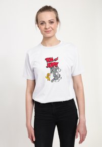 Biała bawełniana koszulka z kolorową grafiką przedstawiającą Toma i Jerriego, z postaciami w stylu kreskówkowym i wyraźnym tekstem, zaprojektowana do codziennego noszenia.