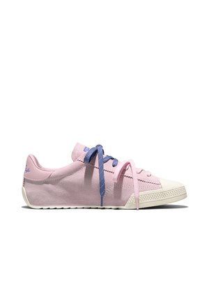 Laag profiel roze suède sneaker met witte neuskap, vlakke witte zool en ongelijk gekleurde blauwe en roze veters, los gestrikt op een witte achtergrond.