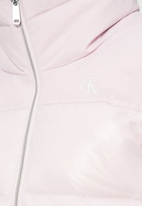 Geacă roz matlasată Calvin Klein cu design matlasat, guler înalt, fermoar complet și logo brodat. Material sintetic neted și lucios.