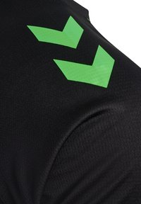 Tissu noir avec deux formes angulaires en chevron vert vif imprimées près de la zone de l'épaule.