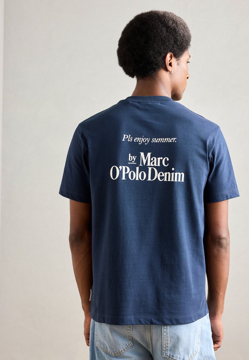 Camiseta azul marino de algodón con cuello redondo; el texto en la parte posterior dice: "Por favor, disfruta del verano. de Marc O’Polo Denim."