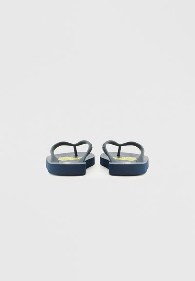 Temno modre japanke z teksturiranim podplatom, gumijastimi trakovi in srčasto obliko na vrhu. Na podplatu je opazen zelen grafični motiv.