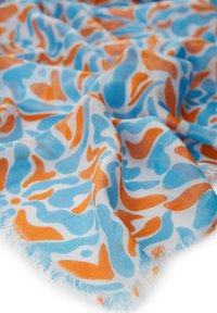 Lichte sjaal met een blauw en oranje abstract patroon op een witte achtergrond, met franjes aan de randen en een zachte, doorschijnende textuur.