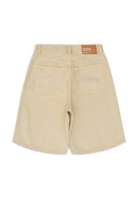 Pantalones cortos de mezclilla beige con corte recto, dos bolsillos traseros y una etiqueta de cuero en la cinturilla. Presenta un dobladillo cosido y costuras en contraste.