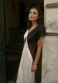 Duga satenska haljina s dizajnom u blok bojama u crnoj, krem i burgundiji, kratkih rukava i V izrezom. Glatka tekstura.