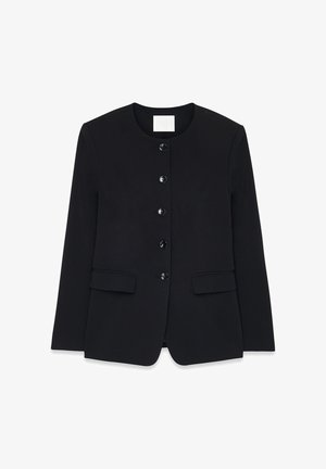 Mustmust vest, mille ümmarguse kaelusega, kuue nööbiga ees ja kahe küljetaskuga. Sile kangas, struktureeritud istuvus ja ilma nähtavate mustriteta.