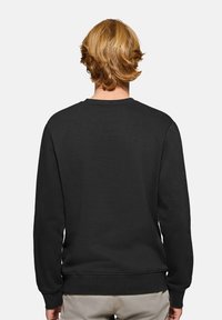 Svart sweatshirt i mjukt tyg, med rund halsringning, långa ärmar och ribbade mudd och nederkant. Bakåtvyn visar en strukturerad yta.