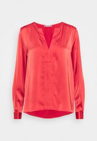 Blouse rouge en satin à manches longues avec un col en V, coupe ample et poignets boutonnés, présentée sur fond blanc uni.
