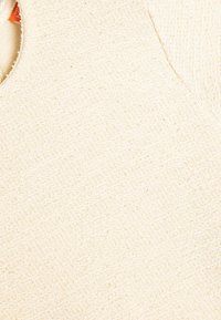 Off-white texturerat tyg med ett något upphöjt m�önster, med en rundad halsringning och en ofärdig kant.