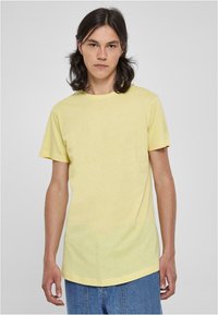 Gul kortærmet t-shirt i et blødt, let stof med en klassisk rund hals og et let buet kantdesign.