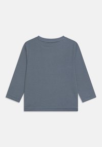 Long-sleeve gray t-shirt made from soft cotton, featuring a round neckline and a straight hem with stitched detailing on the sleeves.