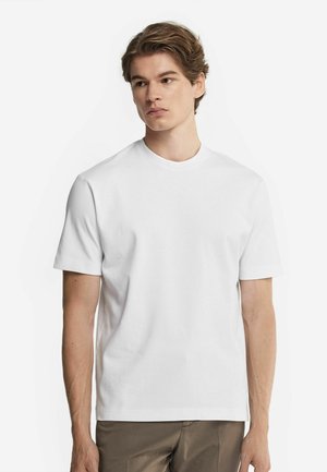 Witte katoenen t-shirt met een ronde hals en korte mouwen, met een regular fit en een gladde textuur, weergegeven tegen een effen achtergrond.