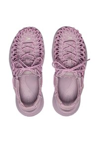 Zapatillas deportivas de color rosa claro con un diseño de parte superior tejido, puntera redonda y suelas de goma con plantilla texturizada y cordones sencillos.