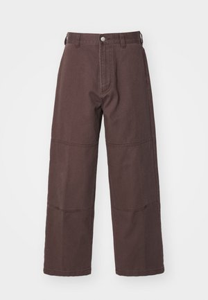 Brązowe spodnie typu wide-leg wykonane z bawełny, z kieszeniami z przodu, z zapięciem na guzik oraz widocznymi detalami przeszycia wzdłuż szwów.