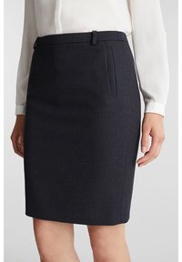 Jupe crayon marine en tissu texturé avec une coupe droite, dotée de poches latérales et de passants de ceinture.