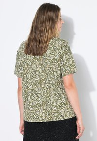 Zelená blůza s krátkým rukávem, zdobená paisley vzorem v bílé a oranžové barvě. Lehká tkanina s uvolněným střihem a zakulaceným lemem.