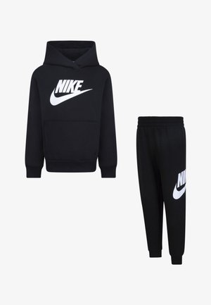 Fekete Nike kapucnis pulóver elülső zsebel és nagy fehér logó; hozzá illő fekete melegítőnadrág fehér logóval a combon. Puha anyag, laza illeszkedés.