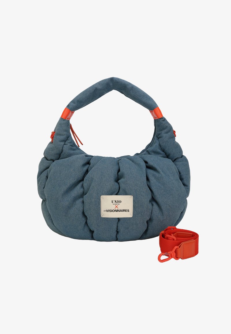 Blaue gepolsterte Stoffhandtasche mit abgerundeter Form, ausgestattet mit einem kurzen Griff und einem abnehmbaren orangen Riemen. Sichtbare silberne Markenplakette.