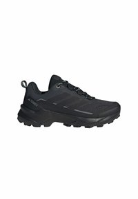 Scarpa da trekking nera con tomaia in mesh, dettagli testurizzati e suola in gomma. Presenta lacci rotondi e un fascetto per una facile vestibilità.