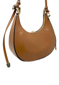 Brązowa skórzana torebka z zakrzywionym kształtem, z ozdobnym złotym zamkiem błyskawicznym i regulowanym paskiem; gładka faktura z kontrastującym czarnym wykończeniem.