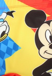 Un short de bain au design coloré mettant en avant Mickey Mouse et Donald Duck. Principalement jaune avec des accents bleus et rouges, texture lisse.