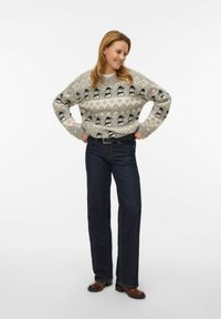 Hall hall helikopter mustriga Fair Isle kampsun, paari tumesiniste teksade ja pruunide kontsaga saapadega. Pehme tekstuur, lõdvestunud lõige, pikad varrukad.