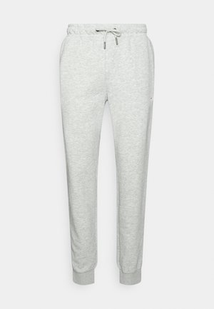 Pantalones deportivos gris claro con cintura elástica con cordón, bolsillos laterales y puños acanalados en los tobillos.