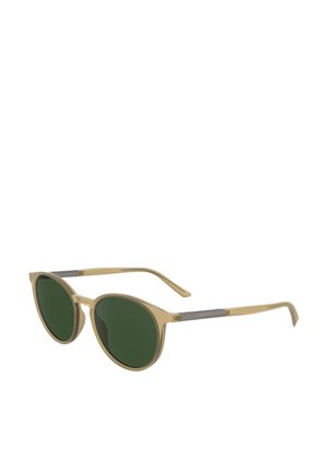 Lunettes de soleil rondes avec une monture transparente beige clair et des verres verts. Présente un fin accent argenté sur les branches. Design léger.