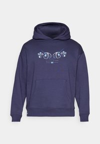 Sudadera azul marina con un bolsillo frontal, que presenta una impresión gráfica de dados y el texto "HISTORY MAKERS". Hecha de una tela suave, con puños acanalados.