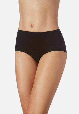 Mujer con ropa interior negra sin costuras de talle alto, mostrada desde la mitad del torso hasta la parte superior de los muslos sobre un fondo liso.