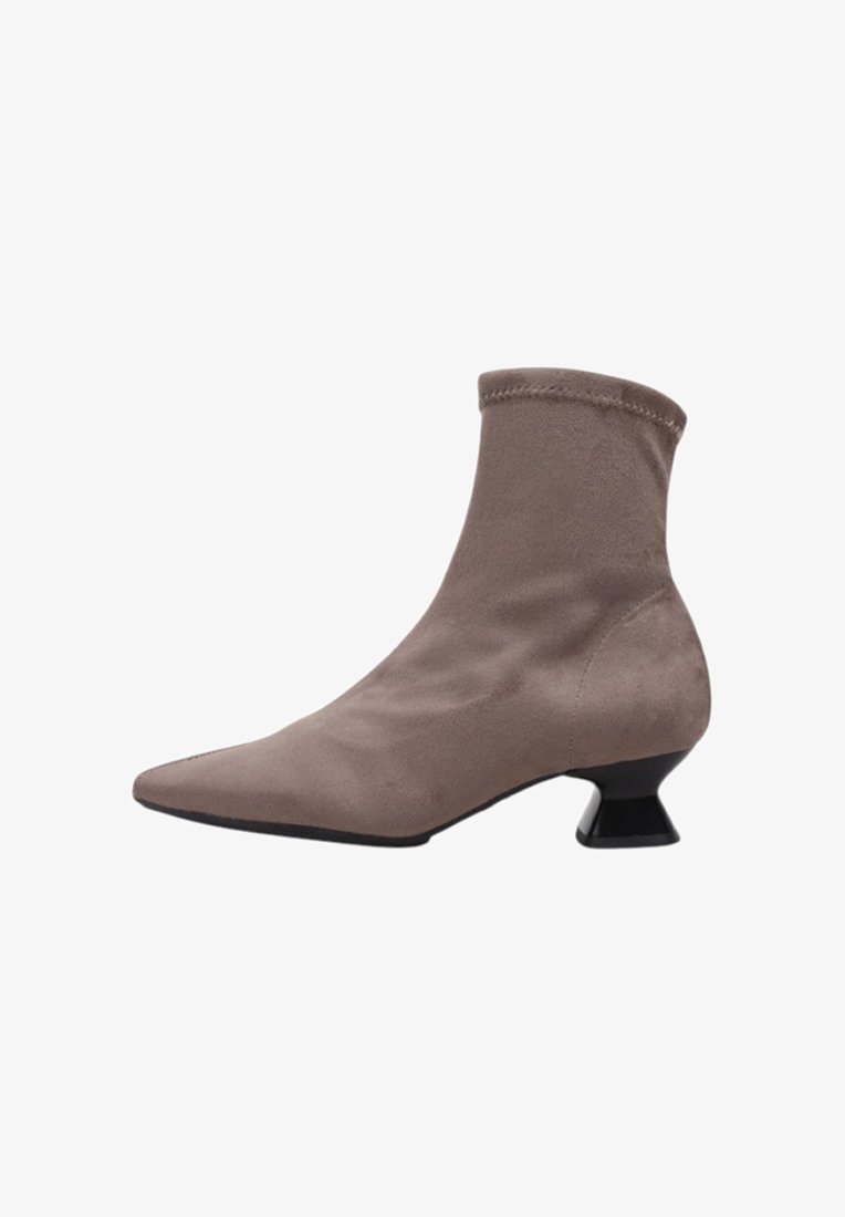 Botte ankle en daim brun avec un bout pointu, un col effilé et un talon géométrique noir. Texture lisse et design minimaliste.