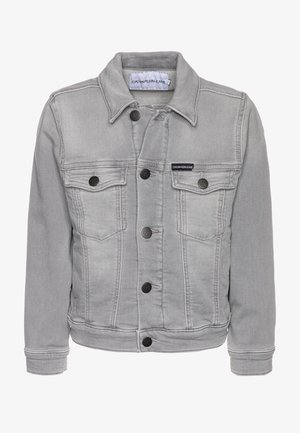 Chaqueta de mezclilla gris claro con botones de metal, dos bolsillos en el pecho y etiqueta de Calvin Klein Jeans en el bolsillo izquierdo y en la etiqueta del cuello.