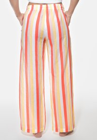 Lniane spodnie szerokie w nogawkach z pionowymi pasami w kolorze pomarańczowym, żółtym i białym, z elastycznym pasem i kieszeniami.