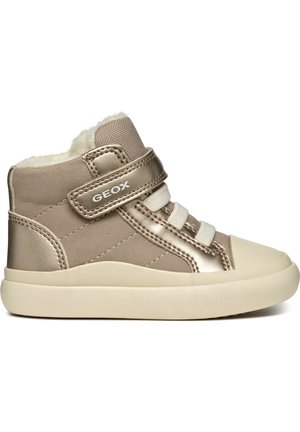 Baskets montantes beiges avec des accents métalliques, des lacets élastiques et une sangle Velcro. Doublure en fourrure douce et semelle en caoutchouc pour un confort optimal.