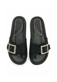 Sandales noires à glisser avec des sangles en textile tissé, ornées d'une boucle en strass. Semelles en caoutchouc, design plat, style décontracté et ouvert.