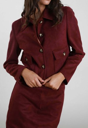 Giacca in suede borgogna con colletto, chiusura a bottoni, due tasche frontali e maniche lunghe, dal texture morbido e design casual.