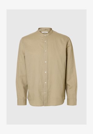 Šviesiai ruda ilgomis rankovėmis marškiniai su mandarinų apykakle ir priekinėmis sagomis, pateikti ant paprasto šviesiai pilko fono.