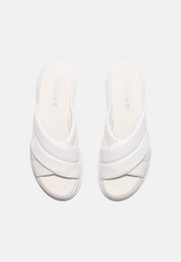 Witte schuif sandalen met gekruiste zachte bandjes, gevoerd voetbed en een gestructureerde zool, met een naadloos ontwerp en minimale branding.