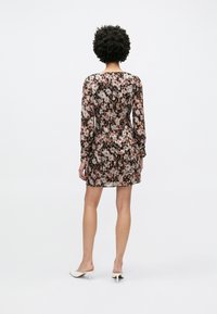 Φλοράλ φόρεμα με μακριά μανίκια, εφαρμοστή μέση και κοντό τελείωμα. Διαθέτει συνδυασμό καφέ, ροζ και κρεμ αποχρώσεων, με διαφανή υφή.