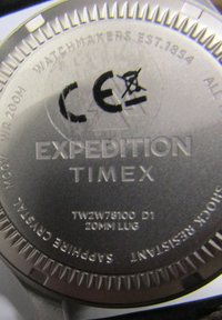Nadir od nehrđajućeg čelika s ugraviranim "EXPEDITION TIMEX", brojem modela, otpornošću na vodu i klasičnim dizajnom s rebrastim rubovima.
