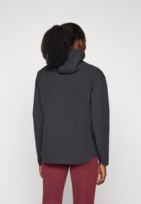 Svart vattentät jacka med hög krage, långa ärmar och en stilren design. Slät yta med minimala sömnadsdetaljer.